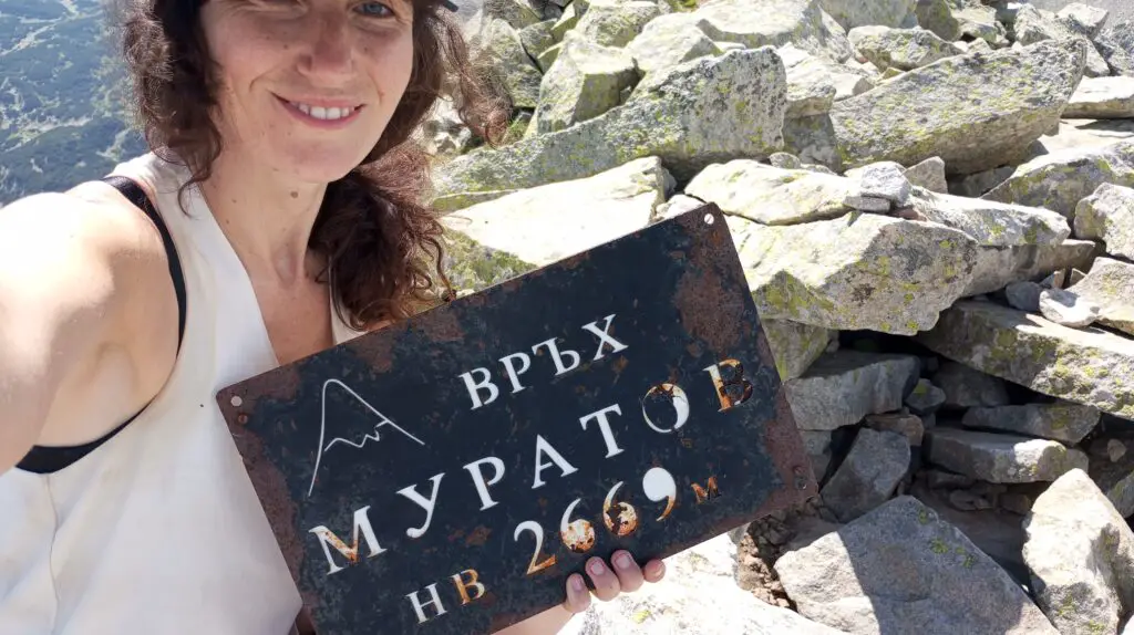 Jessica holding the Muratov Peak sign of 2669m