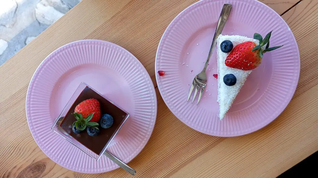 D'Ellicious Cake shop with some coconut cake and a chocolate mousse on some pink plates